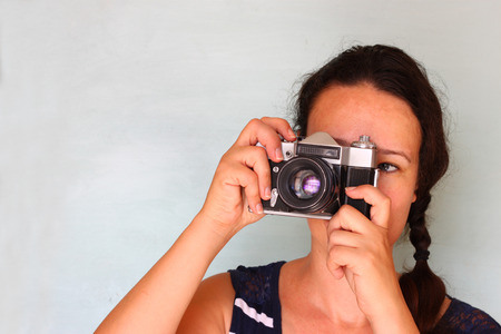 young woman holding old cameraの写真素材