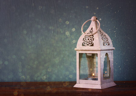 white lantern over wooden table and glitter lights backgroundの写真素材