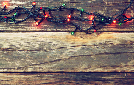 Colorful Christmas lights on wooden  rustic background. retro filtered imageの写真素材