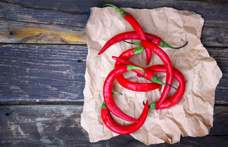 fresh red hot chili peppers on an vintage wooden tableの写真素材
