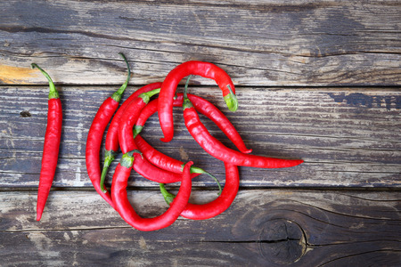 fresh red hot chili peppers on an vintage wooden tableの写真素材