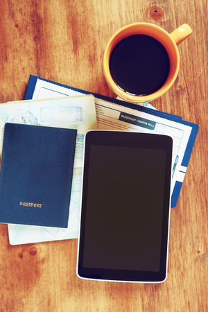 top view image of tablet with empty screen, old camera passport and flight boarding pass.の写真素材