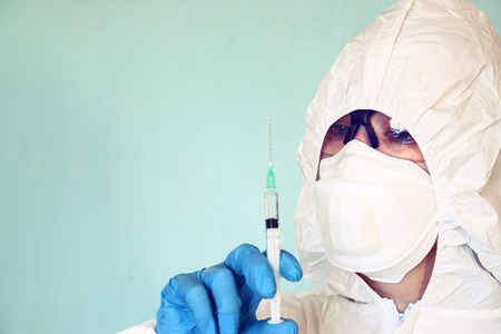 Lab scientist in safety suit With Syringe. selective focus