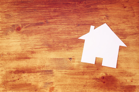 top view of  house shaped paper cut over wooden tableの写真素材