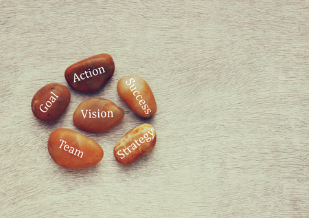river stones with text over wooden background. strategy, success , goal, team conceptの写真素材