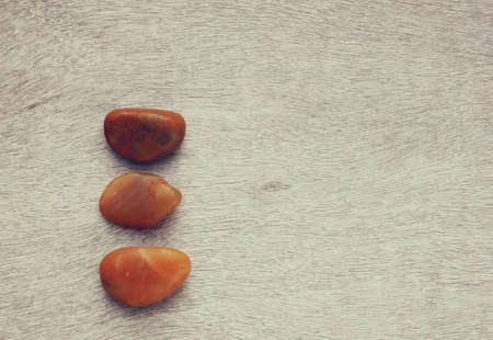 Top view of natural stones on old wooden table.の写真素材