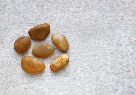 Top view of natural stones on old wooden table.の写真素材