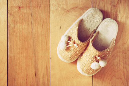 top view of warm woman slippers over wooden floorの写真素材