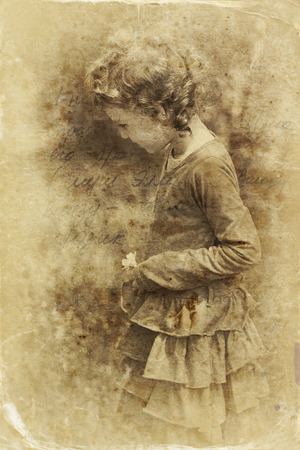 cute little girl playing in the garden. filtered image, old style photoの写真素材