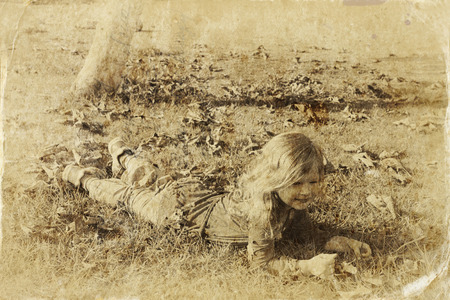 cute little girl playing in the garden. filtered image, old style photoの写真素材