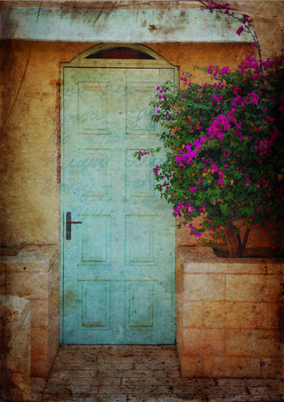 Old blue rustic wooden door and flowers. filtered image with texture overlayの写真素材