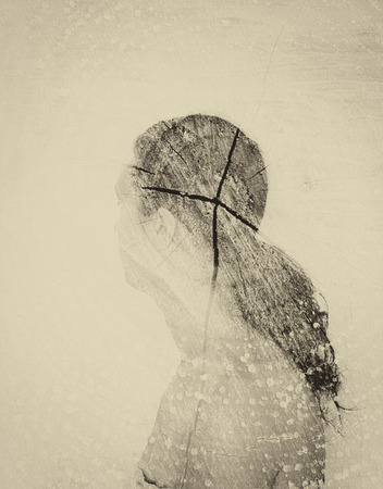 double exposure photo of young woman and tree log texture. image is sepia tonedの写真素材