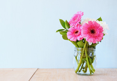 summer bouquet of flowers on the wooden table with mint background. vintage filtered imageの写真素材