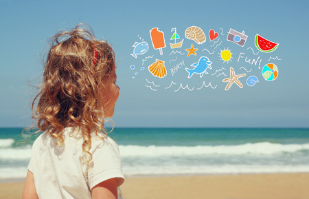 back view of cute girl imagine boat, birds and sun with set of infographics over beach and sea backgroundの写真素材