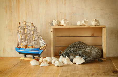 old wooden crate, boat and natural seashells on wooden tableの写真素材