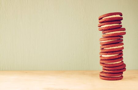 stack of cookies over wooden table next to cup of coffee. image is retro style filteredの写真素材