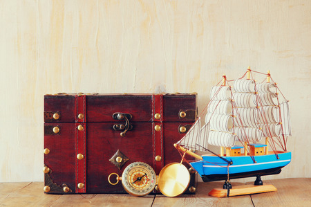 antique compass  wooden boat and old chest on wooden tableの写真素材
