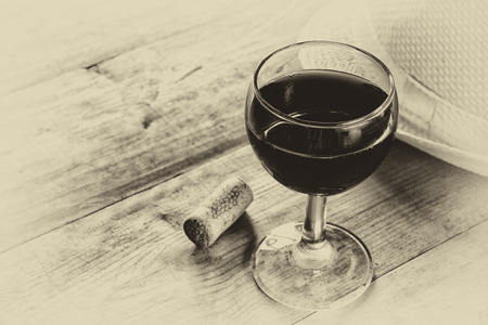 red wine glass on wooden table. vintage filtered image. black and white style photoの写真素材