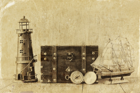 antique compass vintage lighthouse wooden boat and old chest on wooden table. の写真素材