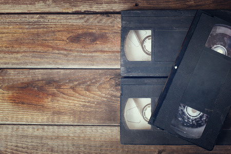 stack of video tape cassette over wooden background. top view photoの写真素材