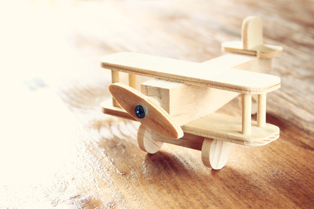 wooden airplane toy over textured wooden background. retro style imageの写真素材