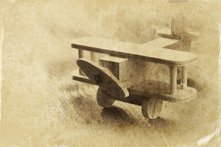 wooden airplane toy over textured wooden background. retro style image.  black and white old style photoの写真素材