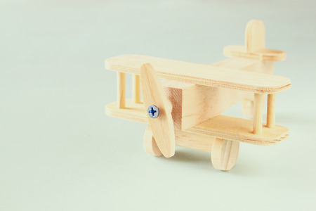 wooden airplane toy over textured wooden background. retro style imageの写真素材