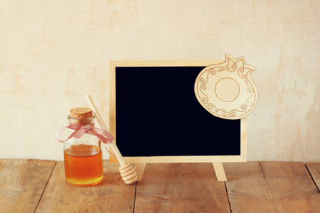 rosh hashanah jewesh holiday concept - honey and pomegranate over wooden table. traditional holiday symbols.の写真素材