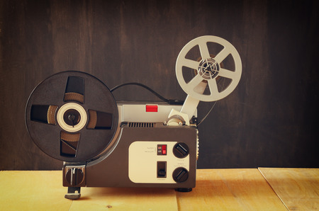 old 8mm Film Projector over wooden table and textured backgroundの写真素材