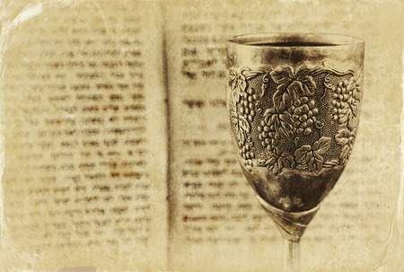 vintage shabbath silver cup of wine in front of torah prayer book. old photo style imageの写真素材