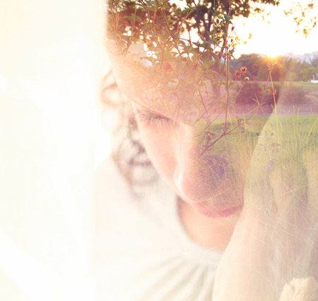 Double exposure of romantic nature landscape and cute happy kidの写真素材