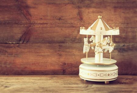 old vintage white carousel horses on wooden table. retro filtered imageの写真素材