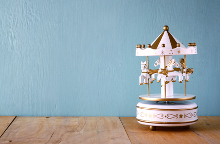 old vintage white carousel horses on wooden table. retro filtered imageの写真素材