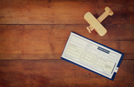top view image of flying ticket wooden airplane over wooden tableの写真素材