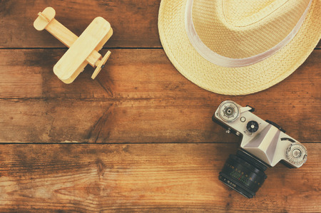 top view image of wood aeroplane, fedora hat and old camera over wooden tableの写真素材