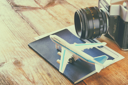 toy airplane and passport over wooden table. retro style imageの写真素材