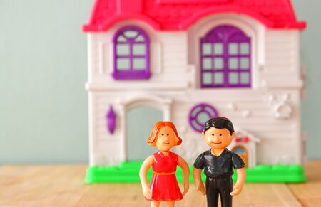concept image of young couple in front of new house. little plastic toy dolls male and female , selective focus.の写真素材