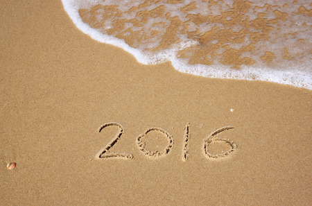 new year 2016 written in sandy beach. image is retro filtered