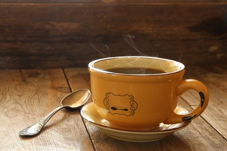cup of coffee on old wooden table.  morning workspace, coffee break .retro filtered image and...