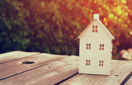 small house model over wooden table outdoors at garden selective focus . filtered imageの写真素材