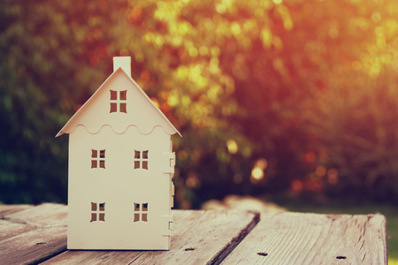 small house model over wooden table outdoors at garden selective focus. filtered imageの写真素材