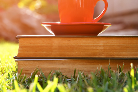 coffee cup mug and book over wooden table outdoors, at afternoon time. selective focusの写真素材