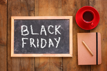 top view image of chalkboard with the text black friday next to cup of coffee and notebookの写真素材