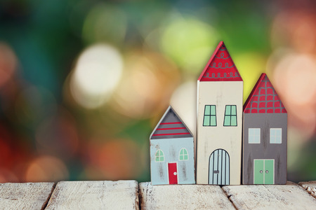 image of vintage wooden colorful houses decoration on wooden table in front of blurred backgroundの写真素材