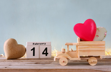 photo of wooden toy truck with hearts. valentine's day celebration concept. vintage filteredの写真素材