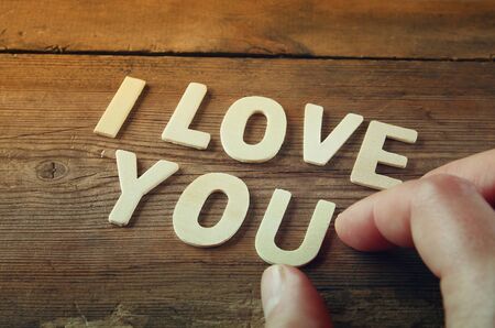 selective focus photo of The words "i love you" made with block wooden letters on wooden background. valentine's day celebration concept. vintage filtered and tonedの写真素材