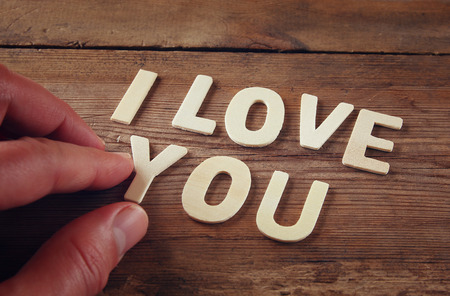 selective focus photo of The words "i love you" made with block wooden letters on wooden background. valentine's day celebration concept. vintage filtered and tonedの写真素材