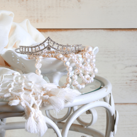 image of white pearls necklace and diamond tiara on vintage table. selective focusの写真素材