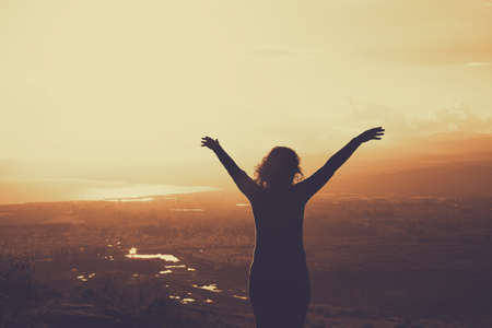 woman against landscape looking at the horizon, inspirational image. retro filterの写真素材