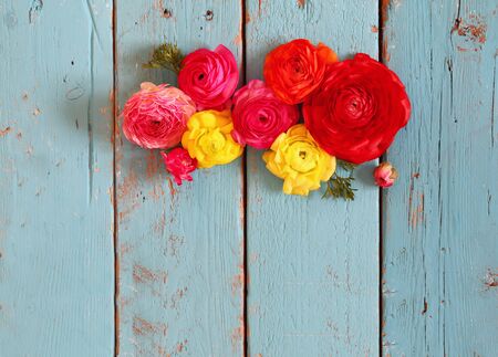 top view of colorful spring flowers on blue wooden background. vintage filteredの写真素材